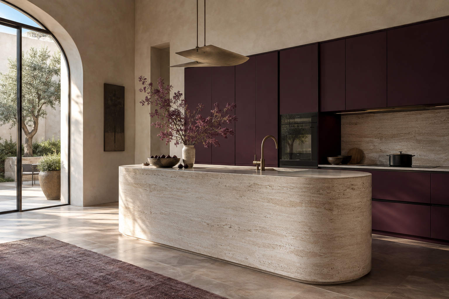 Sculptural aubergine kitchen with a rounded travertine island